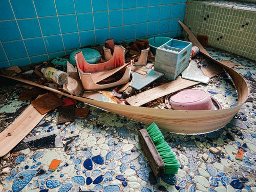 藍色タイルを敷き詰められた倒壊した古民家の風呂の写真