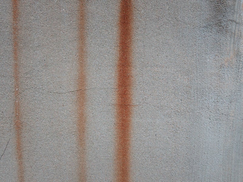 錆が流れるコンクリートの壁の写真