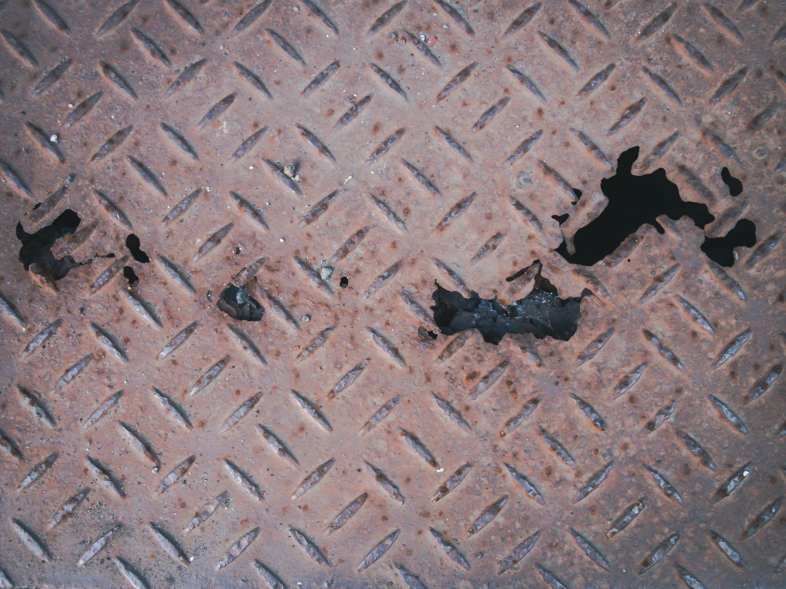 「錆びて（腐食して）穴が空いた金属の足場」の写真