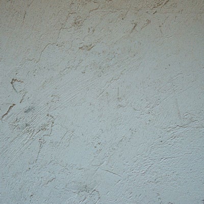 引っかき傷のような模様の塗装が施された壁の写真