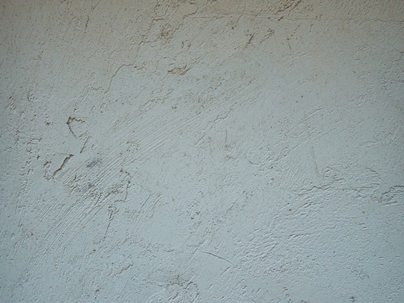 引っかき傷のような模様の塗装が施された壁の写真