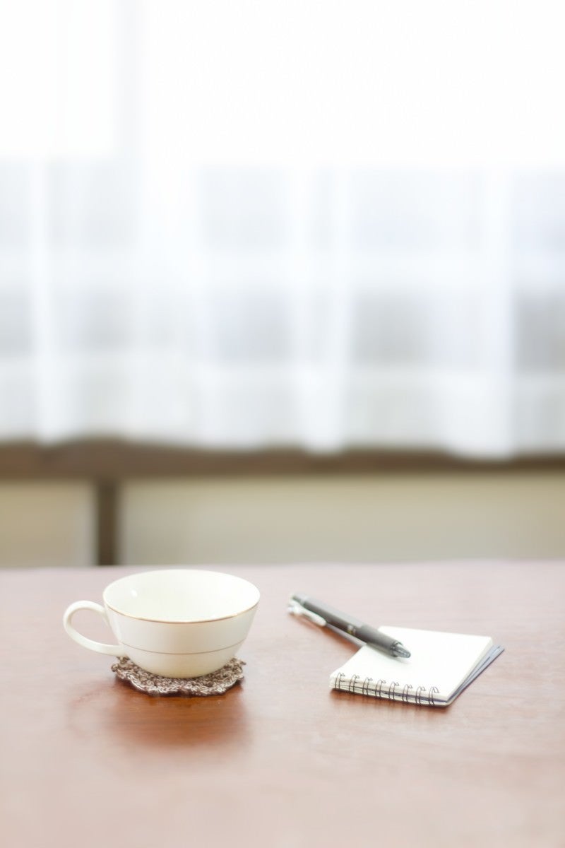 コーヒーカップとメモ帳の写真