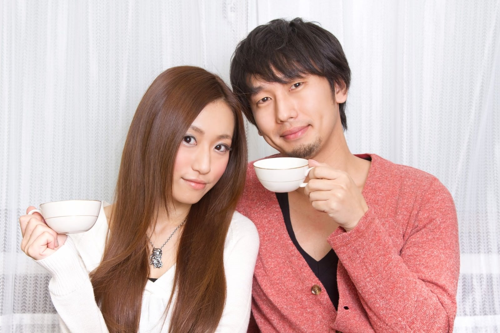 「二人でコーヒーカップを持つ若い夫婦」の写真［モデル：大川竜弥 北野佑々］
