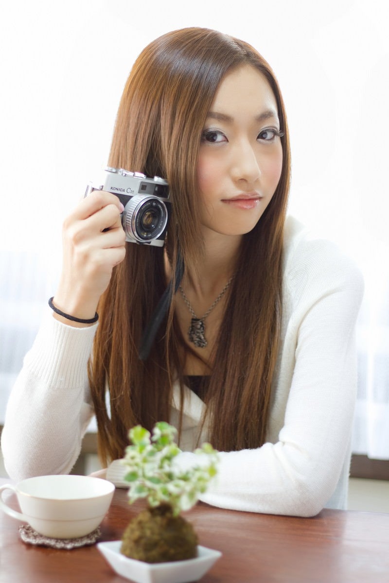 「レトロなカメラを持つ女性」の写真［モデル：北野佑々］