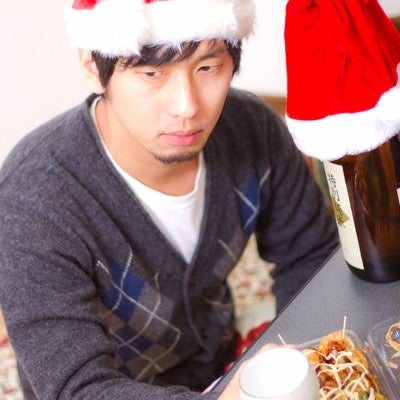 孤独なクリスマスでもお酒とおつまみがあれば負けない！表情の男性の写真
