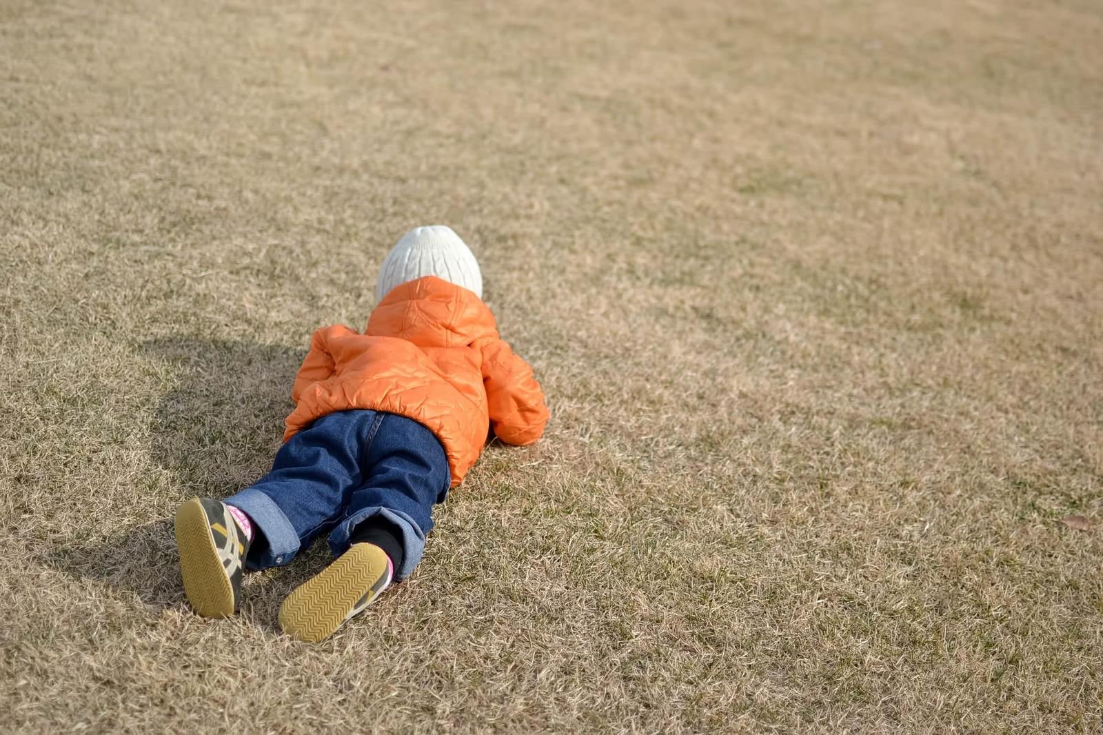 「芝に寝転ぶ子供」の写真