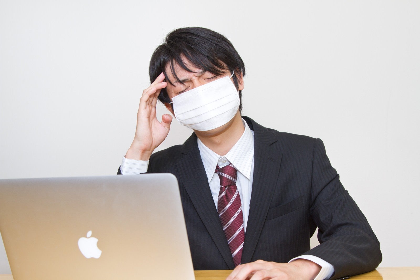 「風邪をひいても残業するサラリーマン」の写真［モデル：Tsuyoshi.］