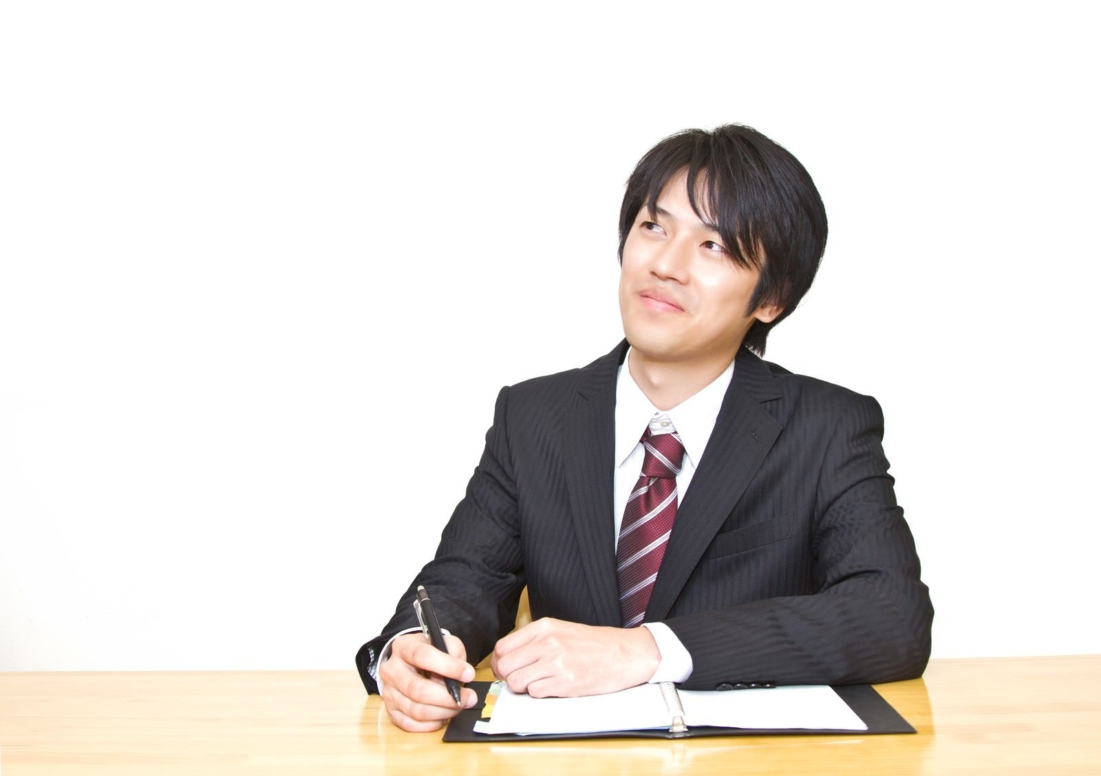 「手帳を広げるスーツの男性」の写真［モデル：Tsuyoshi.］