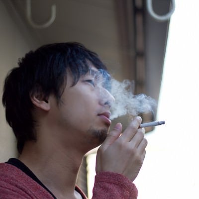 ベランダで煙草を吸う（煙モクモク）の写真