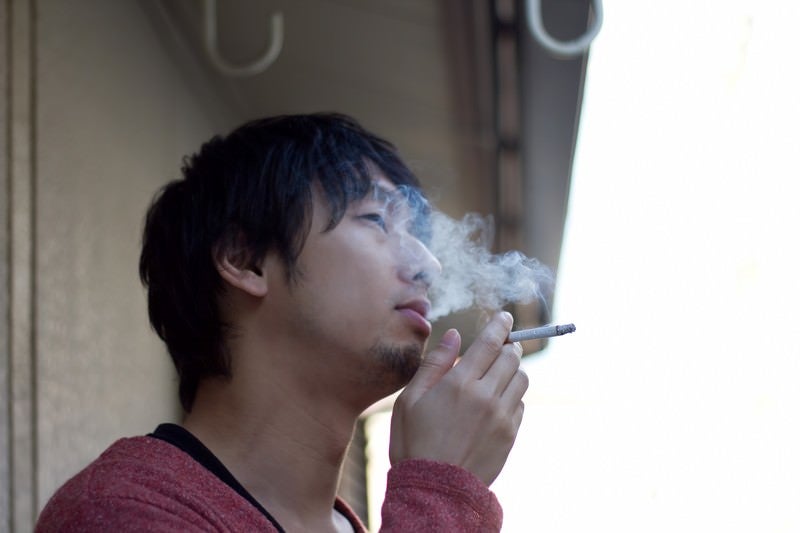ベランダで煙草を吸う（煙モクモク）の写真