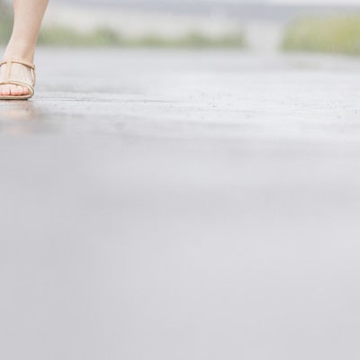 雨道を歩く（女性の足元）の写真
