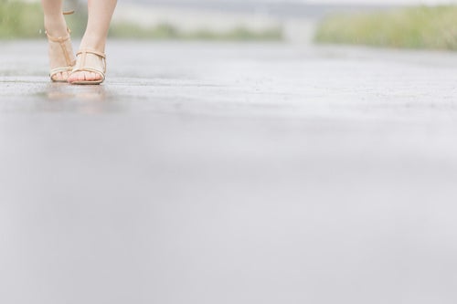 雨道を歩く（女性の足元）の写真