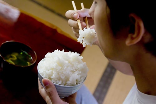 茶碗の白米を食べる様子の写真