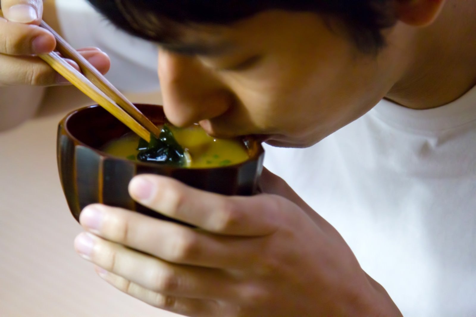 「お味噌汁をすする男性」の写真［モデル：大川竜弥］