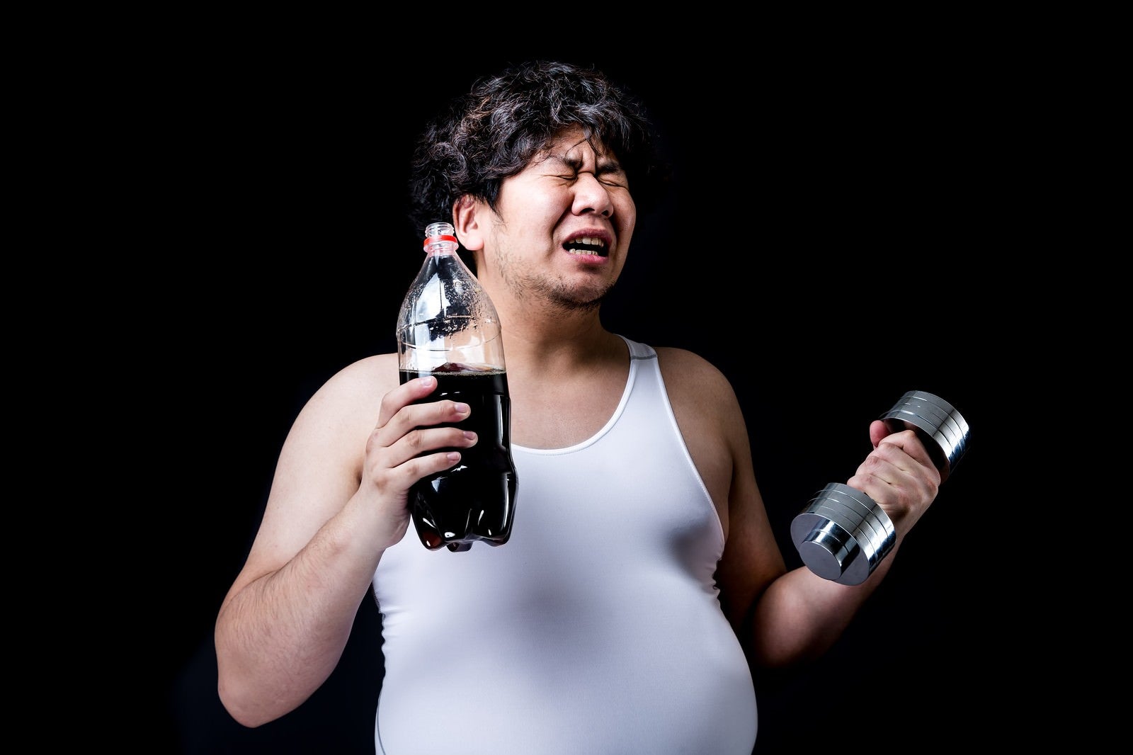 「コーラの重さでダンベルの重さを決めるダイエッター」の写真［モデル：朽木誠一郎］
