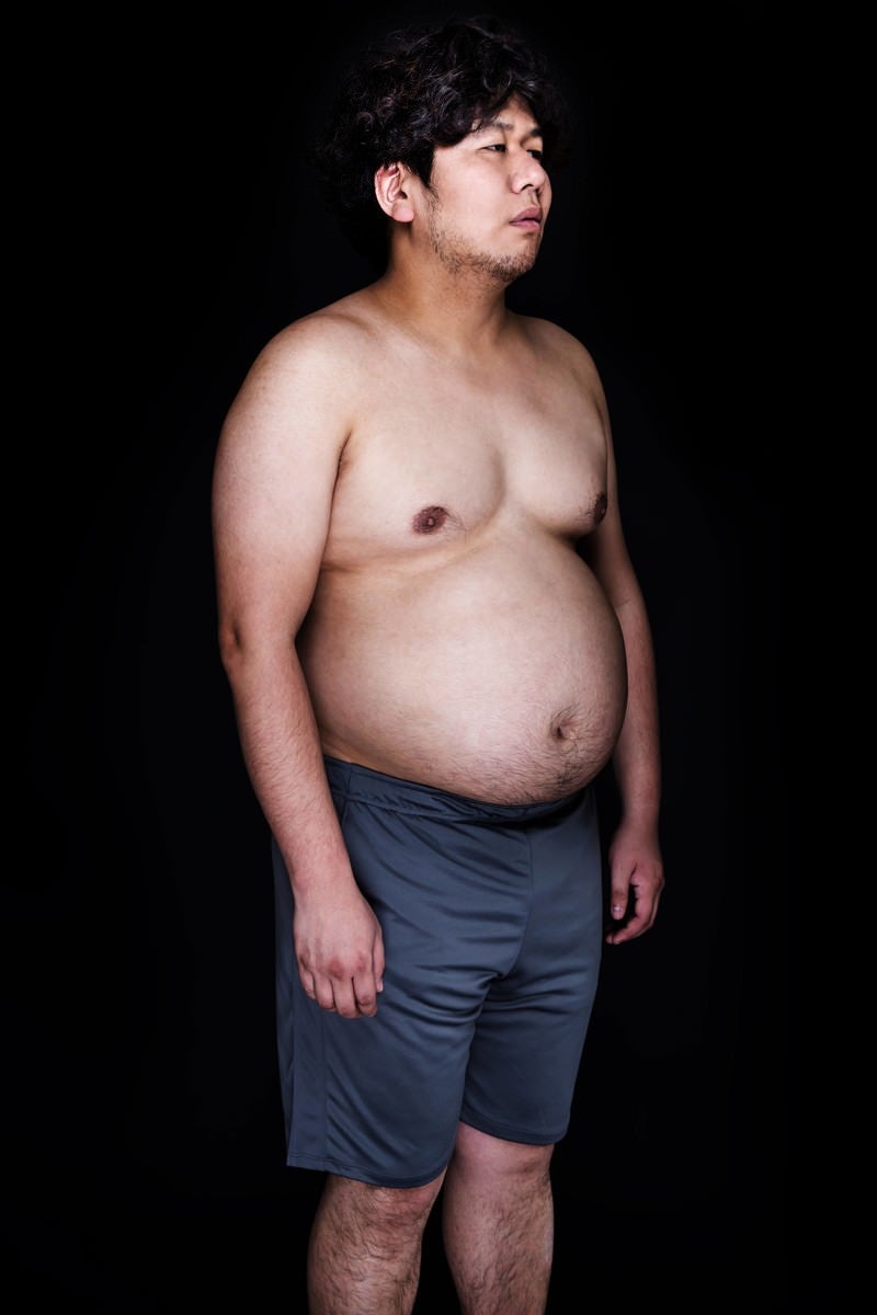 「皮下脂肪たっぷりの腹部と同じ表情をするリアルマリオネット」の写真［モデル：朽木誠一郎］