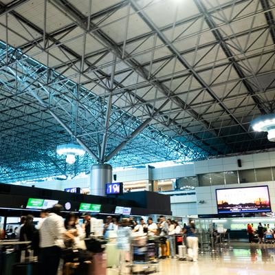 チェックインカウンター前で手続きを待つ人々の写真