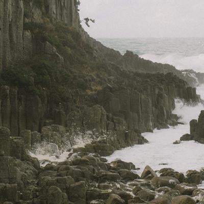 鉾島の岩場に集まる荒波の写真