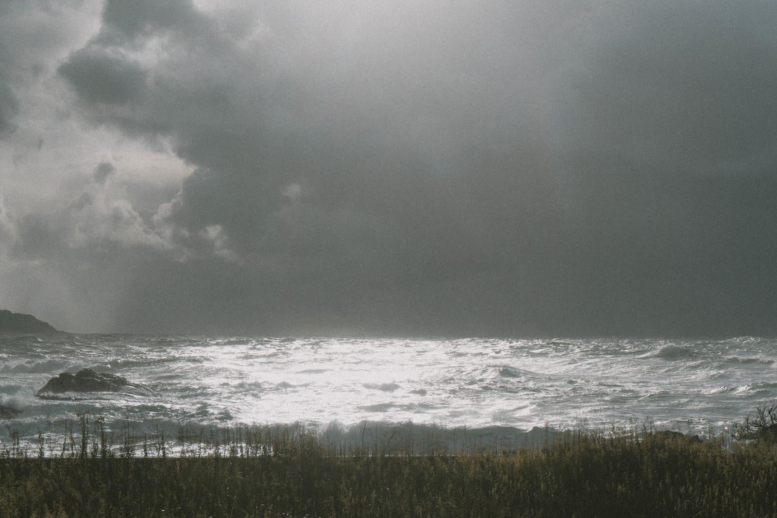 「暗雲と光のコントラストが美しい冬の日本海」の写真