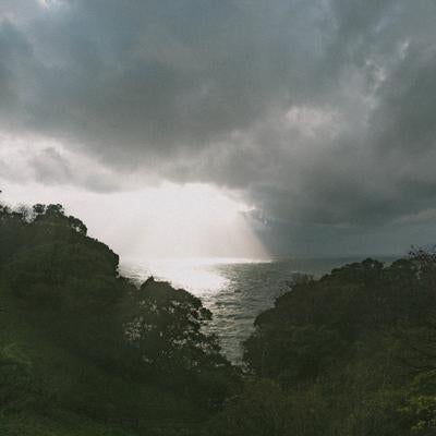 雲間から差し込む光が輝く冬の日本海の写真