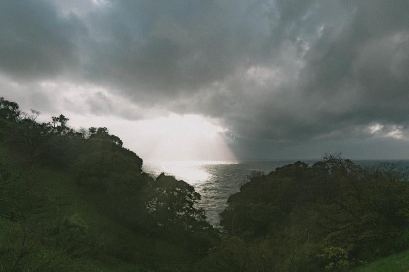 雲間から差し込む光が輝く冬の日本海の写真