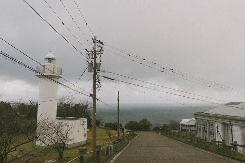 海を見下ろすように立つ白い越前岬灯台の写真