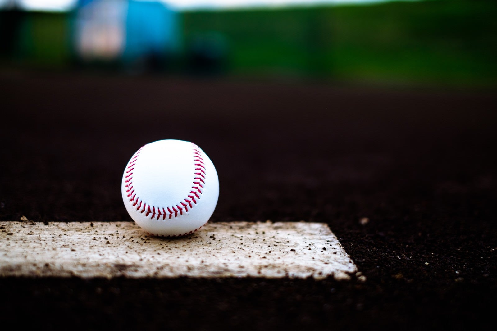 「ベース上に置かれた野球のボール」の写真