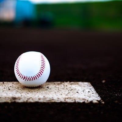 ベース上に置かれた野球のボールの写真