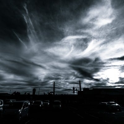 駐車場からの雲行き（モノクロ）の写真
