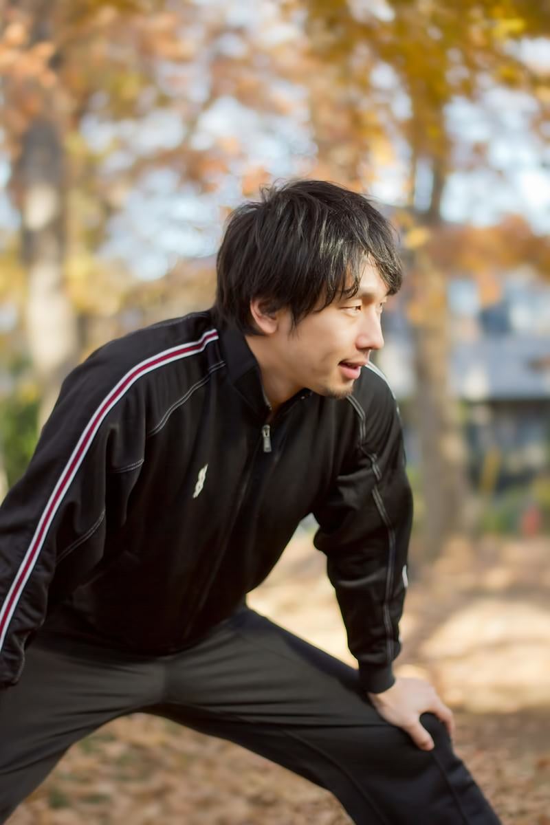 「準備運動をするジャージの男性」の写真［モデル：大川竜弥］