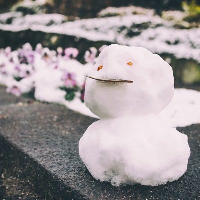 ちょっとだけ積もった雪で作った小さな雪だるまの写真