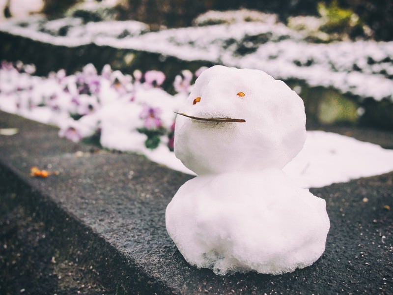 ちょっとだけ積もった雪で作った小さな雪だるまの写真