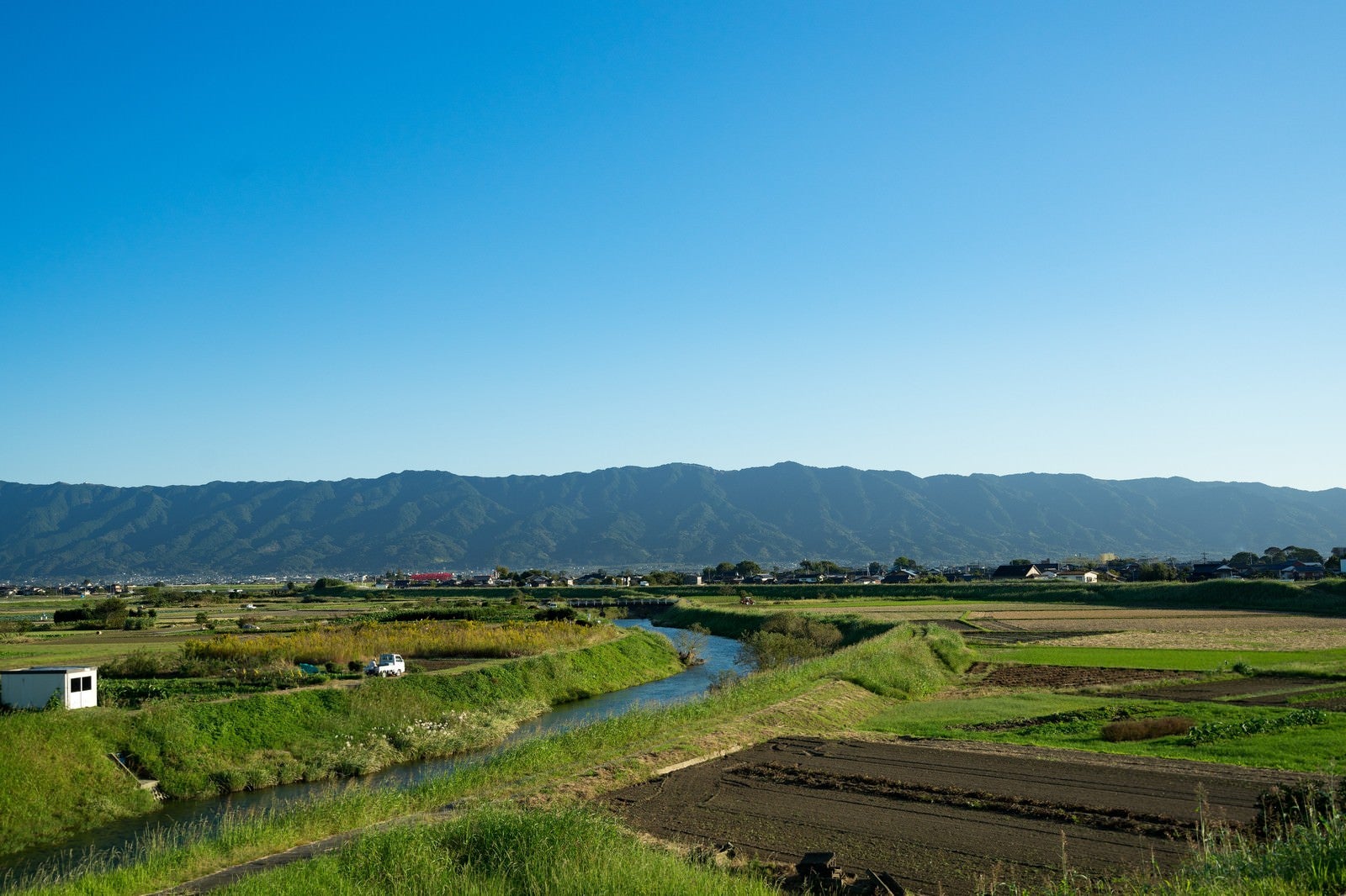「青空、山、農地のほどよいバランス（福岡県大刀洗） | フリー素材のぱくたそ」の写真