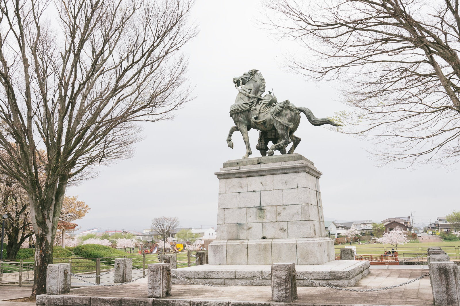 「菊池武光像と大刀洗公園の桜」の写真
