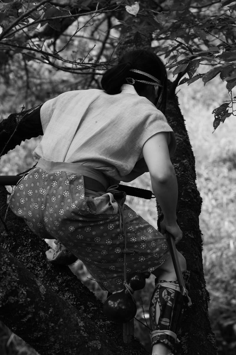 「木の陰に隠れる野盗」の写真［モデル：まーこ］
