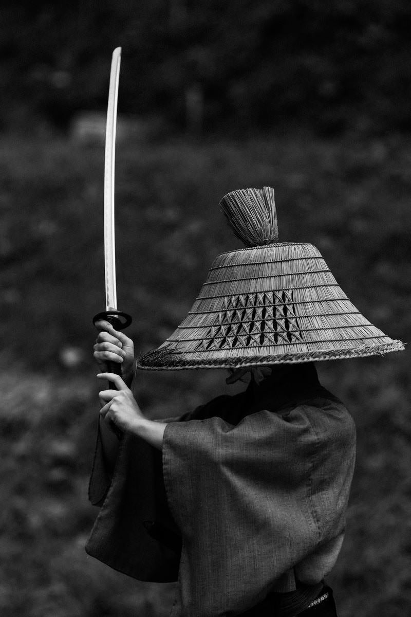 「刀を高く上げて構える侍」の写真［モデル：まーこ］