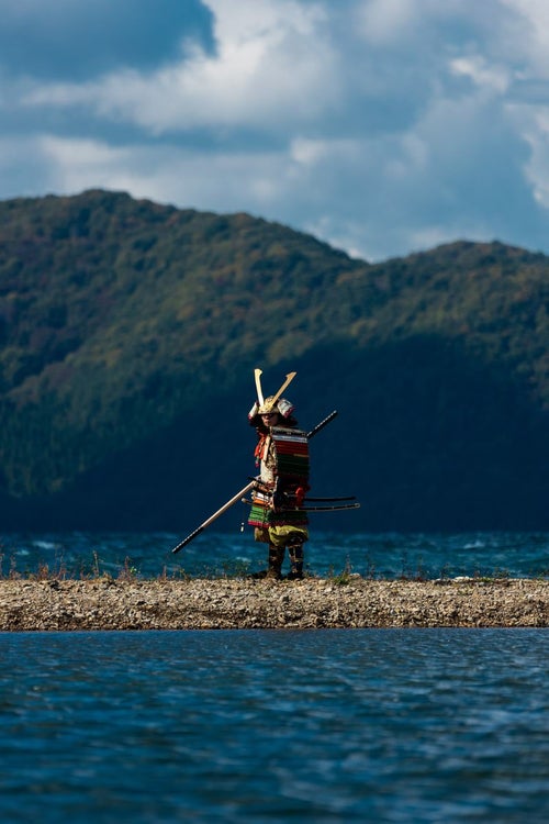 猪苗代湖に佇む大鎧を纏う武士の写真