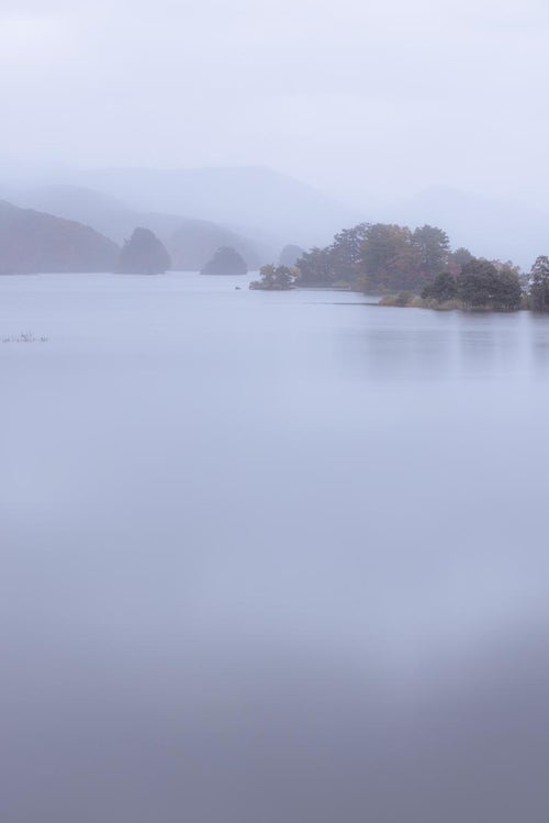 朝霧が包む秋元湖と静けさの中の神秘的な朝の写真