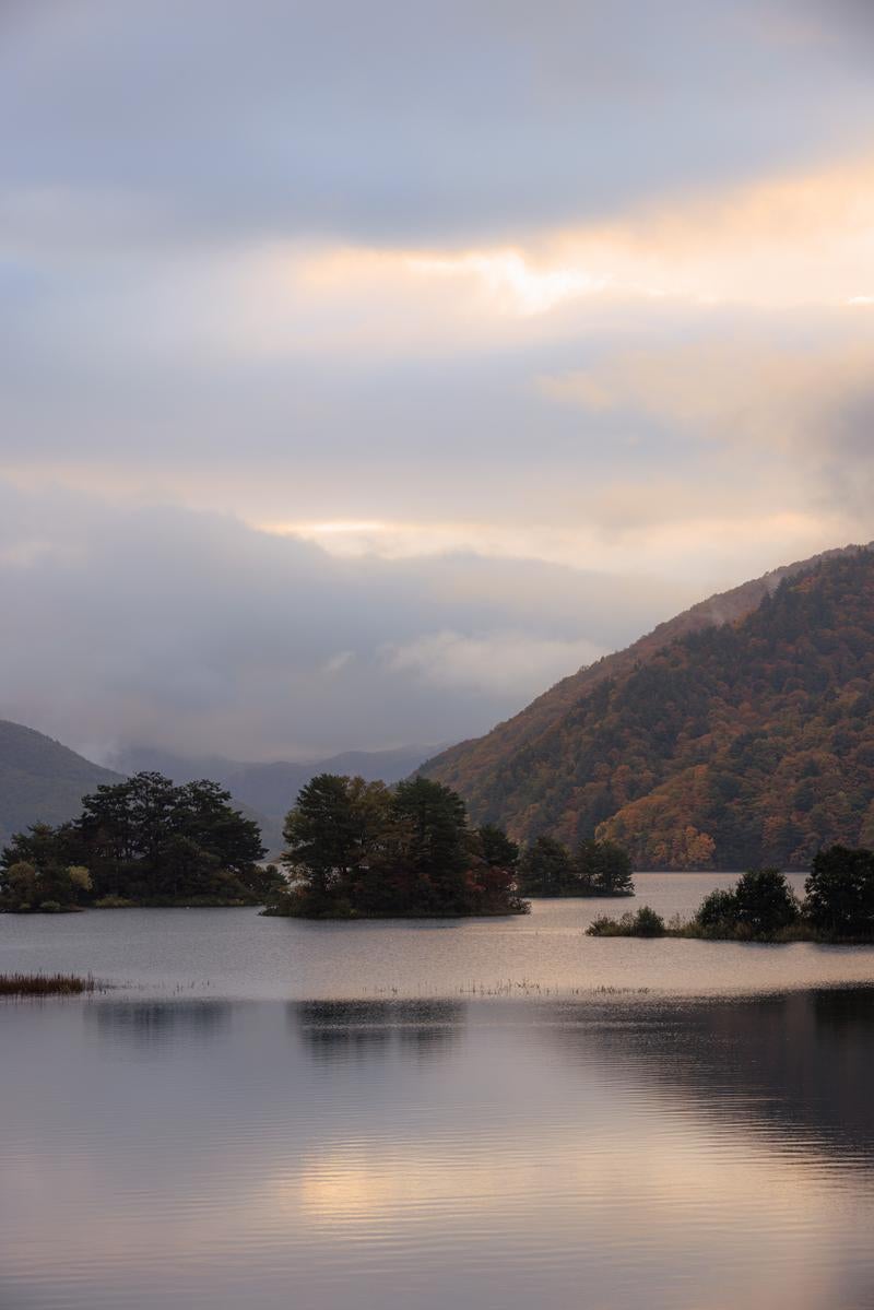 「雲間の朝焼けと秋元湖の静寂」の写真