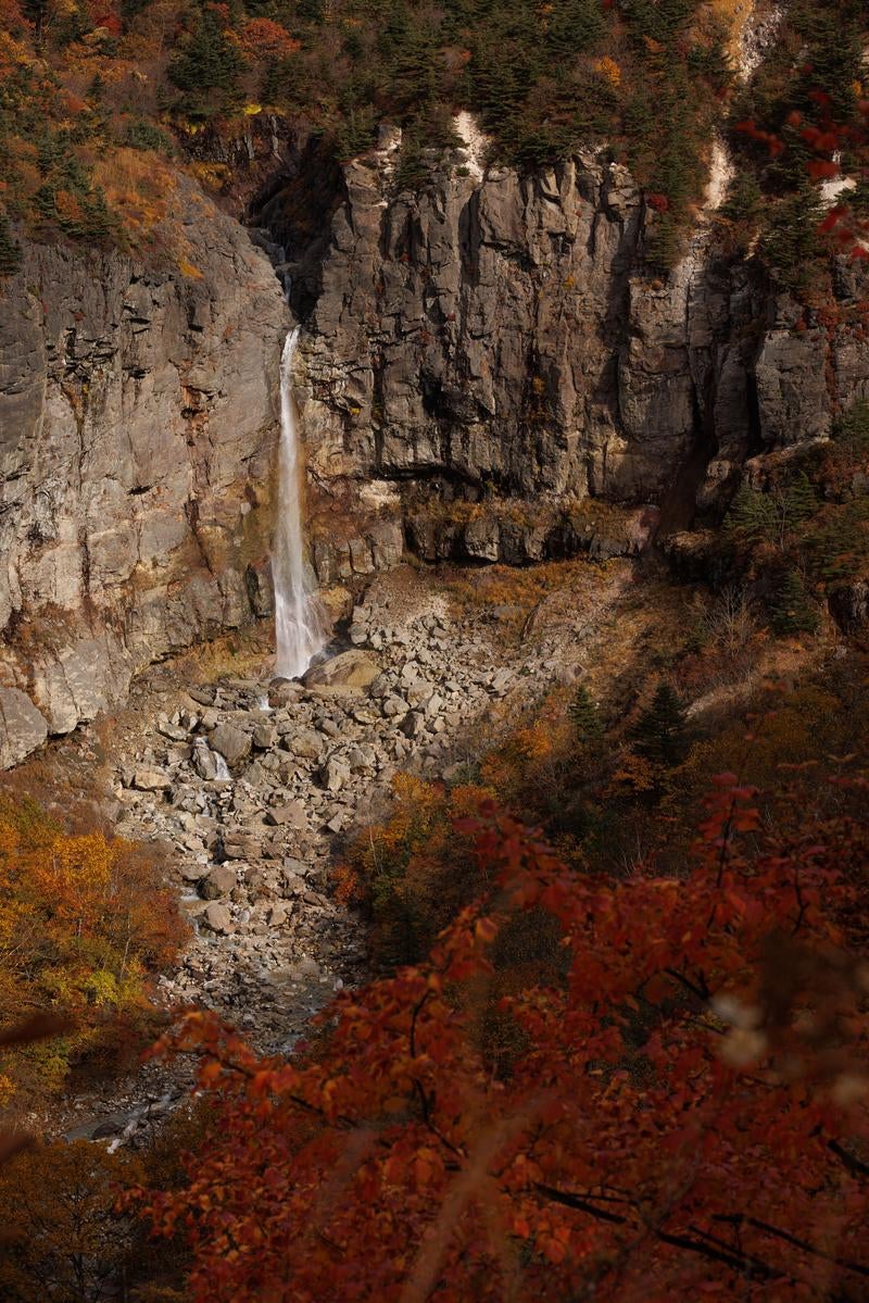 「断壁と紅葉の調和する白糸の滝」の写真