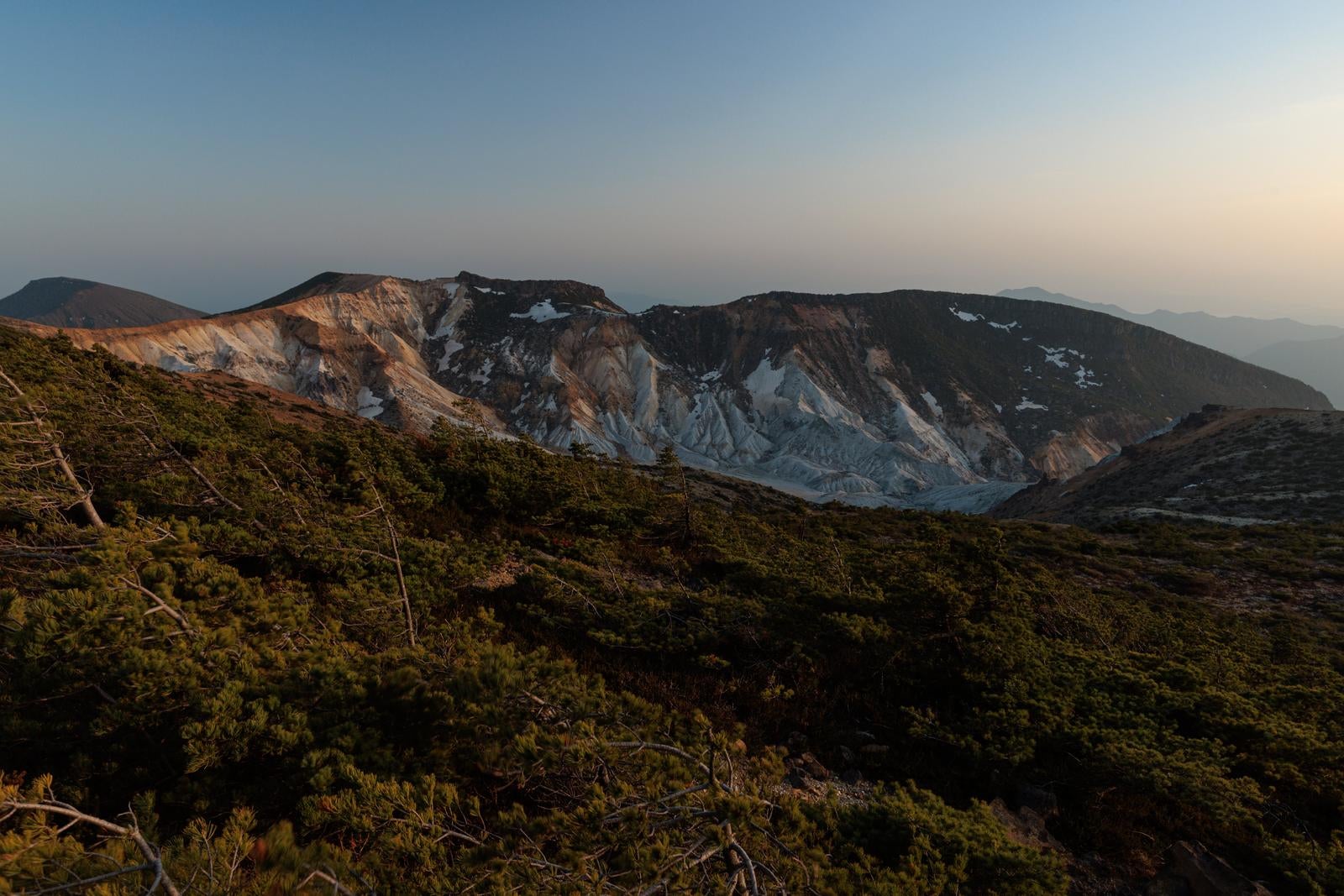 「新緑に包まれた夕焼けと鉄山避難小屋周辺の風景」の写真