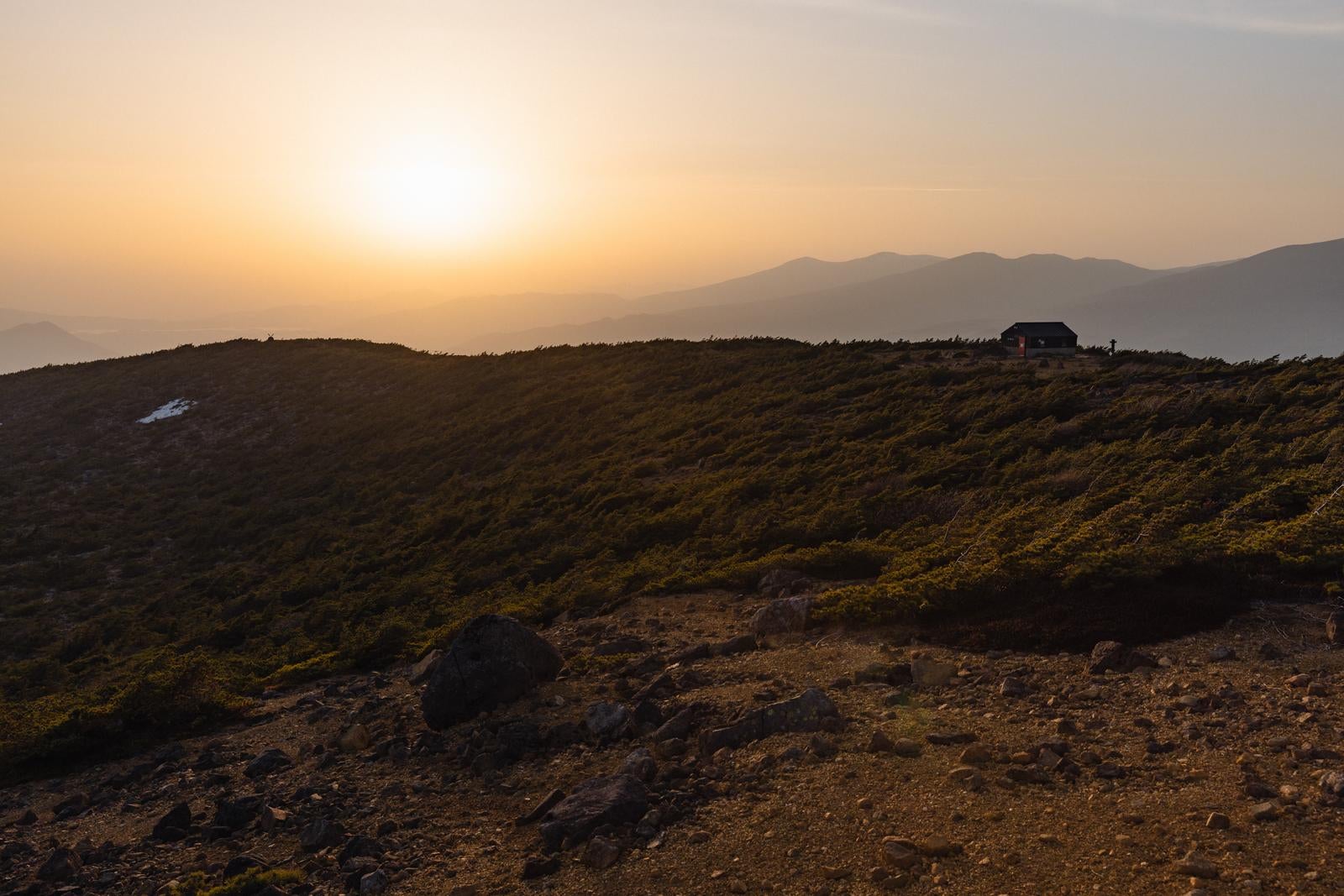 「夕焼けの鉄山避難小屋、夕日が作り出す山の美」の写真