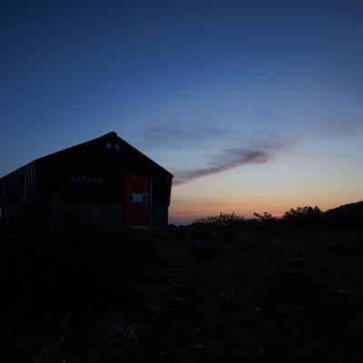 薄明に浮かぶ鉄山避難小屋のシルエットの写真