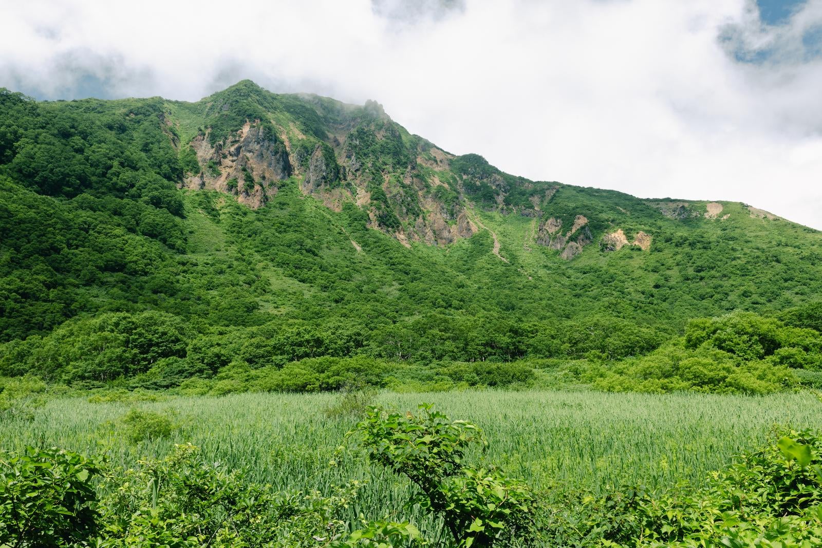 「磐梯山猪苗代登山口から見る、山肌に沸き立つ雲の壮大な景色」の写真