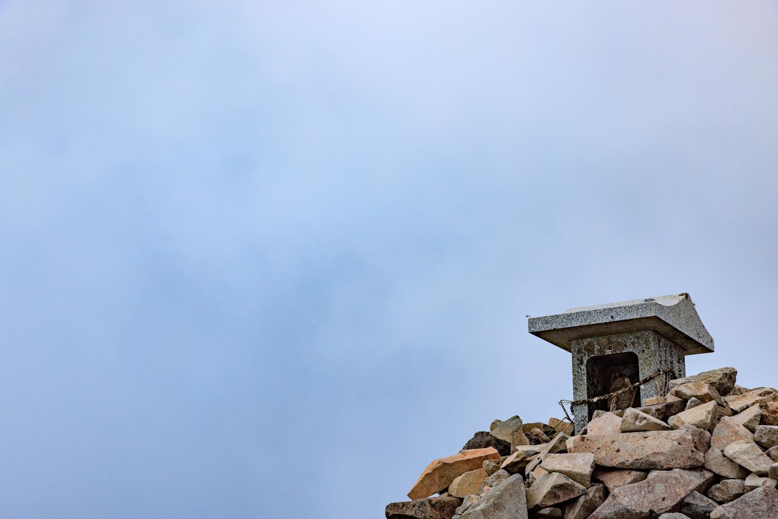 「磐梯山の頂上で発見する祠とガスの神秘的な景色」の写真