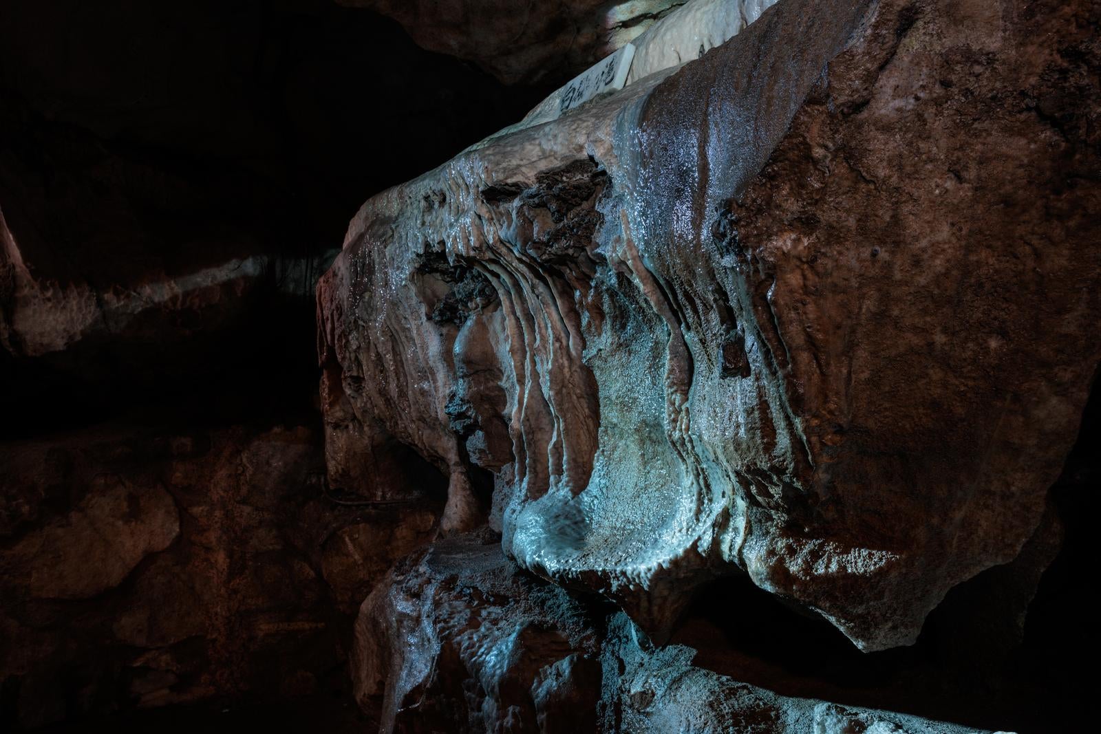 「濡れた鍾乳石が映す洞内の輝き」の写真