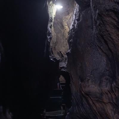 足元を照らす光と共に入水鍾乳洞の洞内通路探検の写真