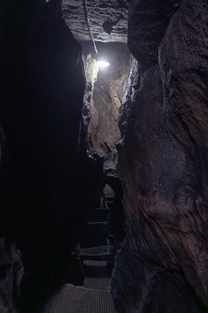 「足元を照らす光と共に入水鍾乳洞の洞内通路探検」の写真