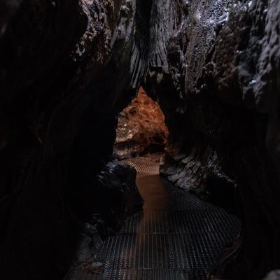濡れた通路をたどる入水鍾乳洞の洞内の写真