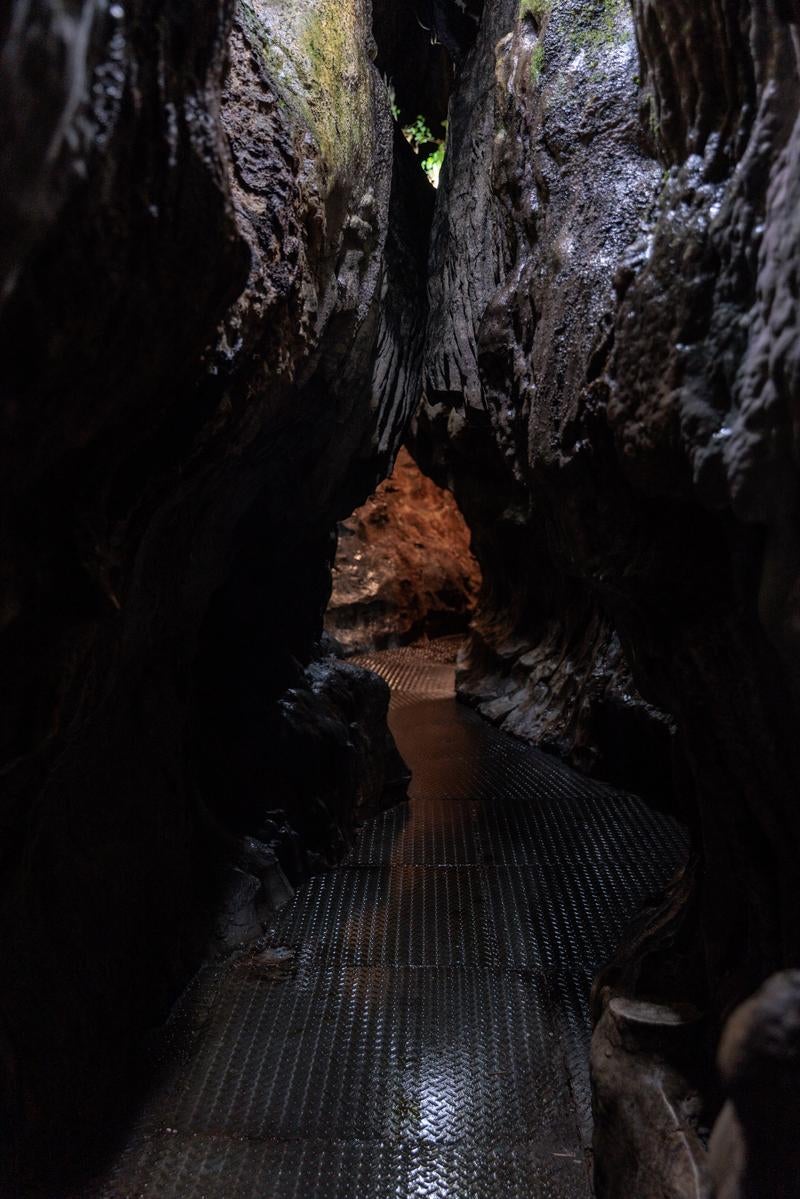 「濡れた通路をたどる入水鍾乳洞の洞内」の写真